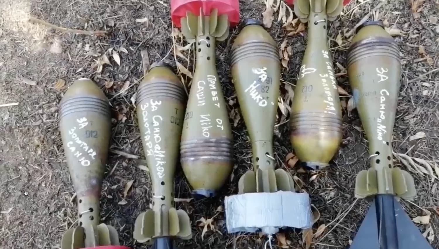 Mortar shells fitted with 3D-printed tail fins laid out on the ground.
