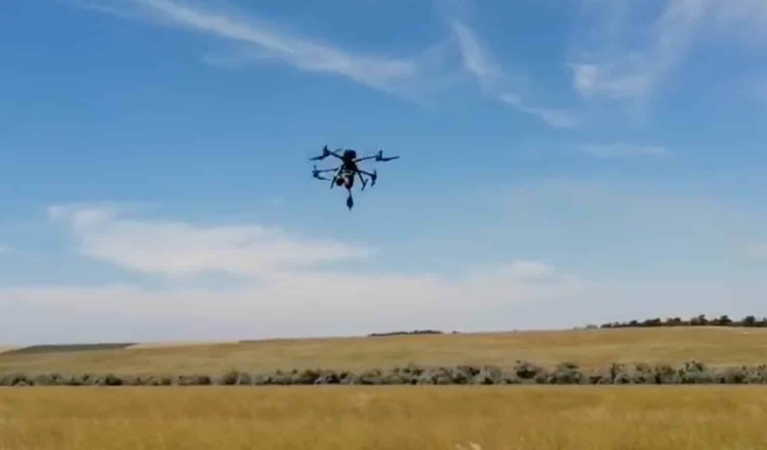 DJI Matrice 300 RTK hovering above an open field under a clear sky.