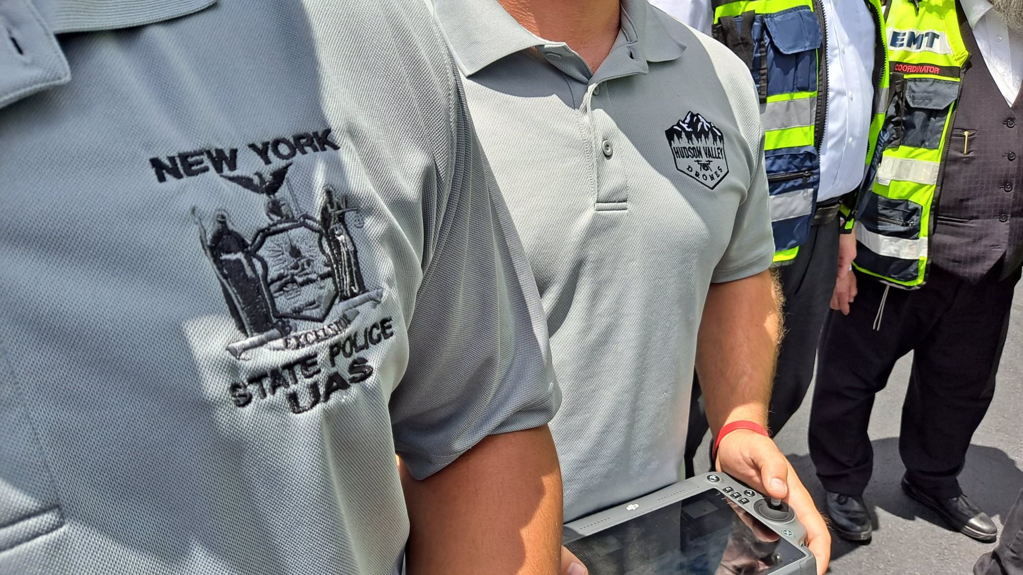 New York State Police UAS unit shirt as an officer holds a drone controller.