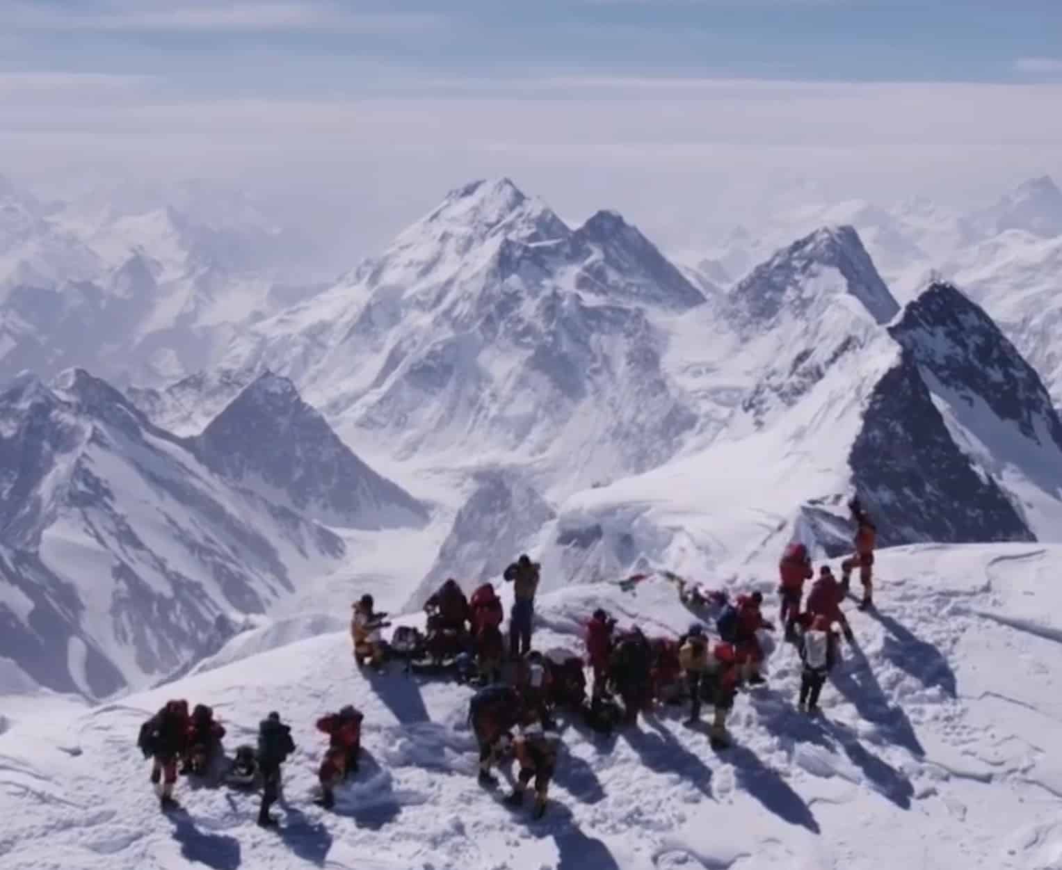 Aerial view of a queue of climbers on a snowy ridge below K2.