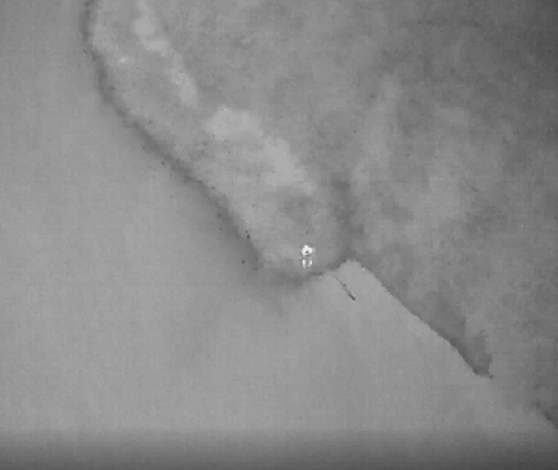 Thermal aerial view of a river with one small bright signature near the bank.
