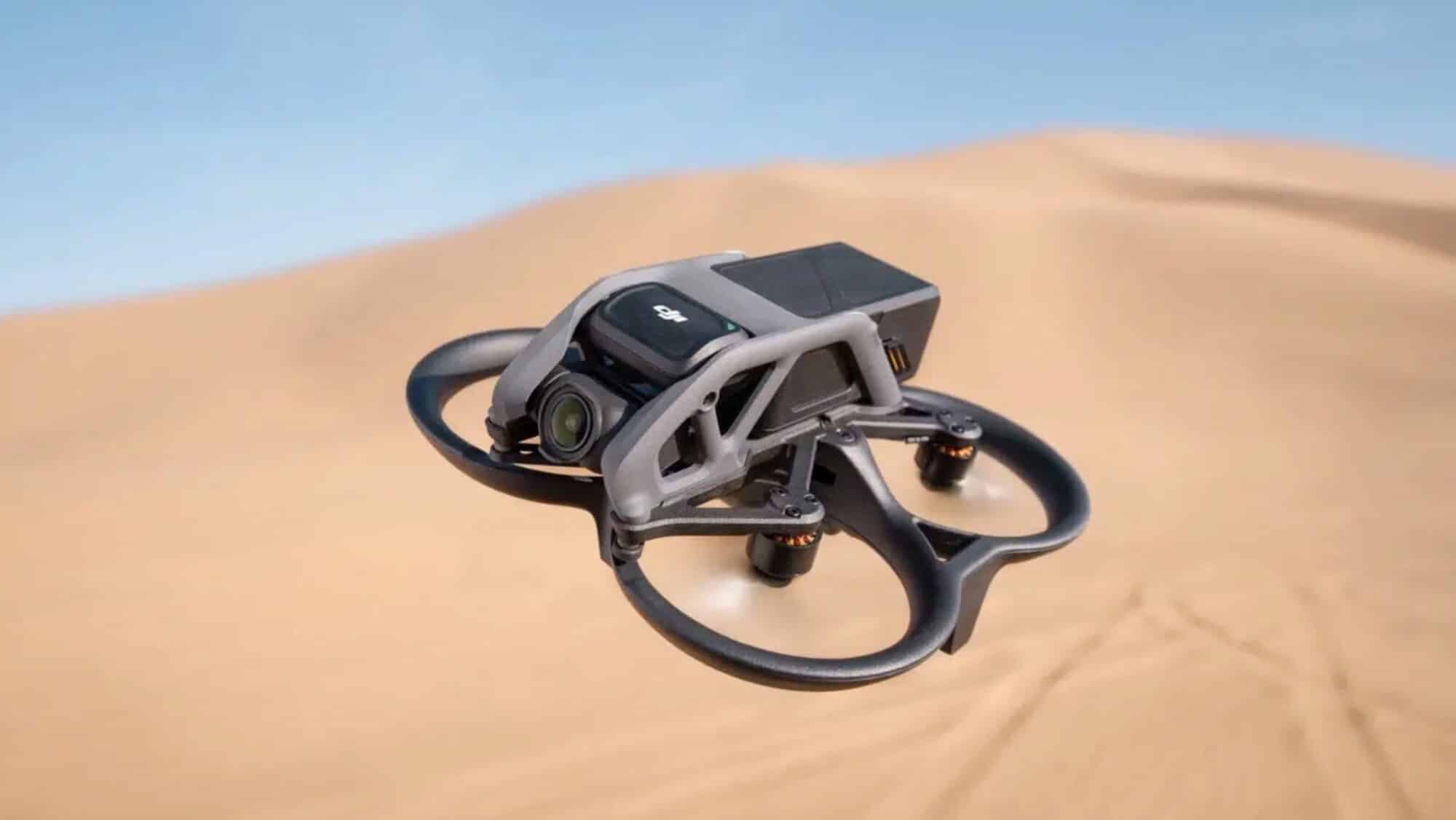 DJI Avata cinewhoop skims low over rippled desert sand dunes.