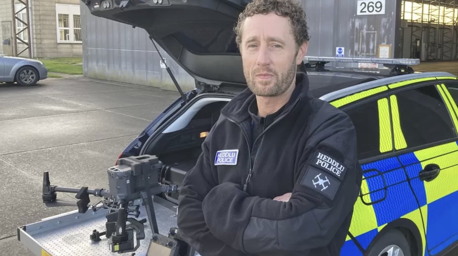 North Wales Police Sergeant Paul Terry standing with a DJI Matrice 300 behind him.