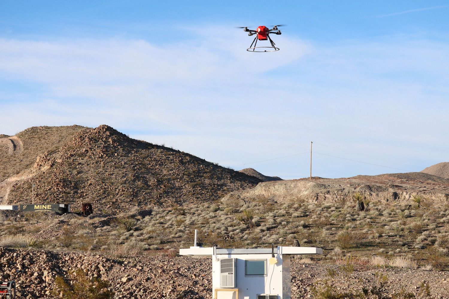 The Scout lifts off from its automated base station in remote desert terrain.