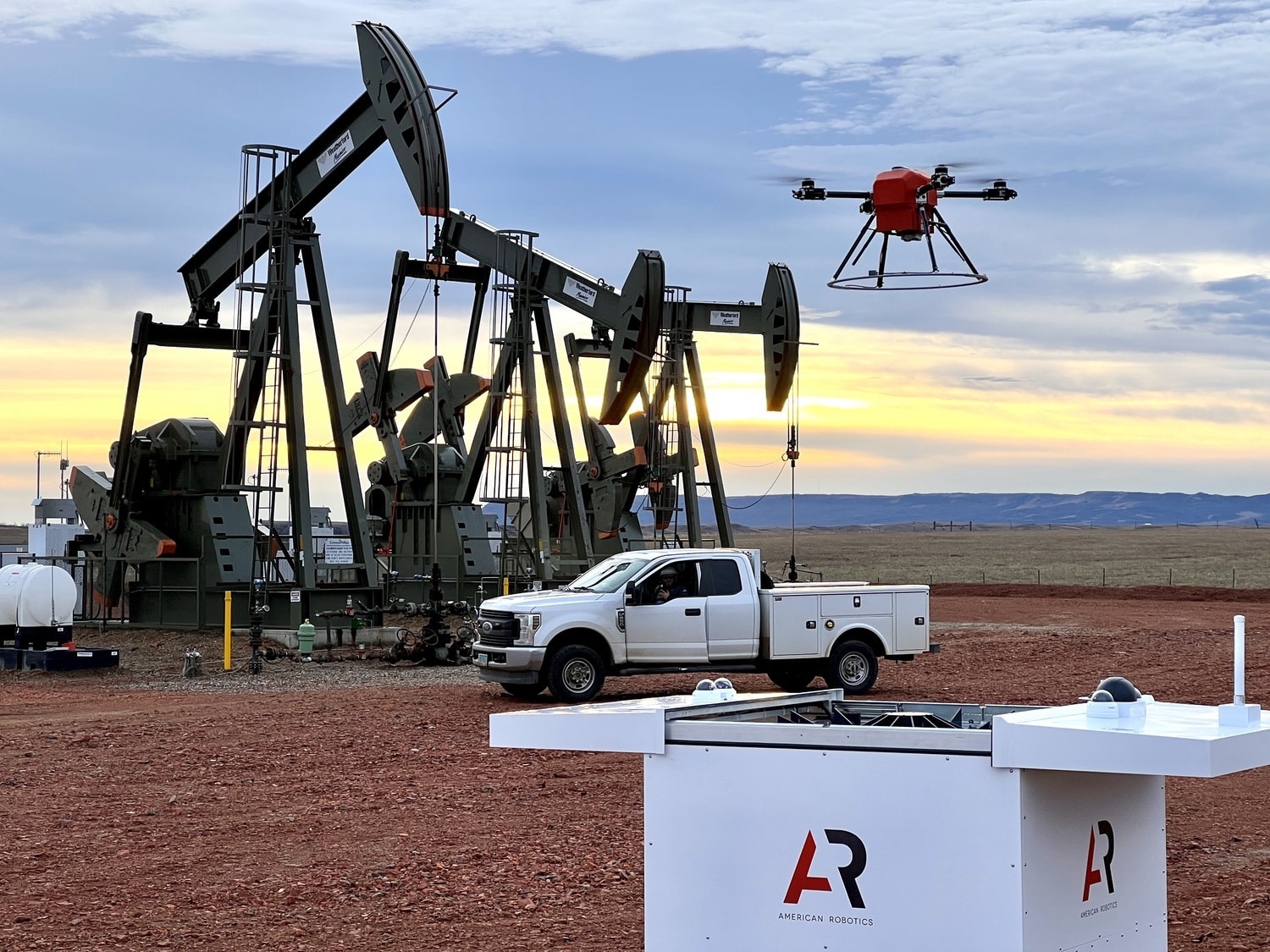 An American Robotics Scout drone flies past pumpjacks at an oil field site.
