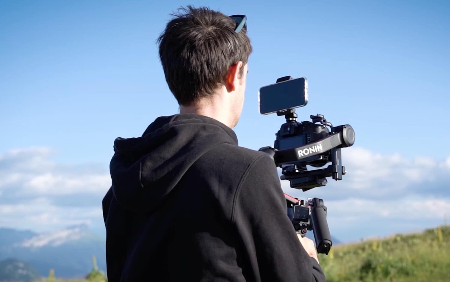Operator carrying a camera on the DJI RS3 gimbal alongside the runners.