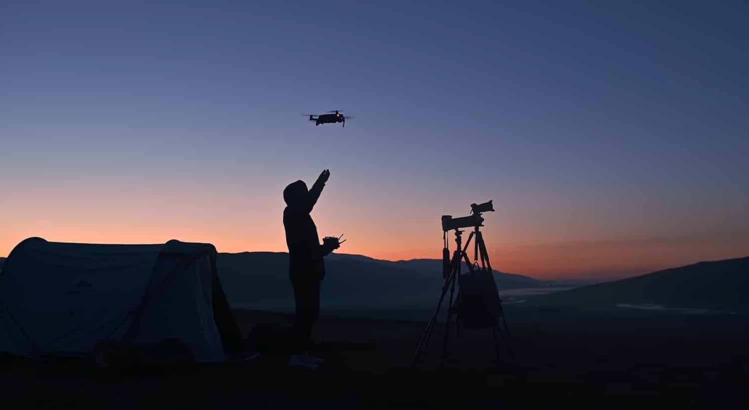 Silhouette of a pilot reaching for a drone at sunset beside a telescope and tent.