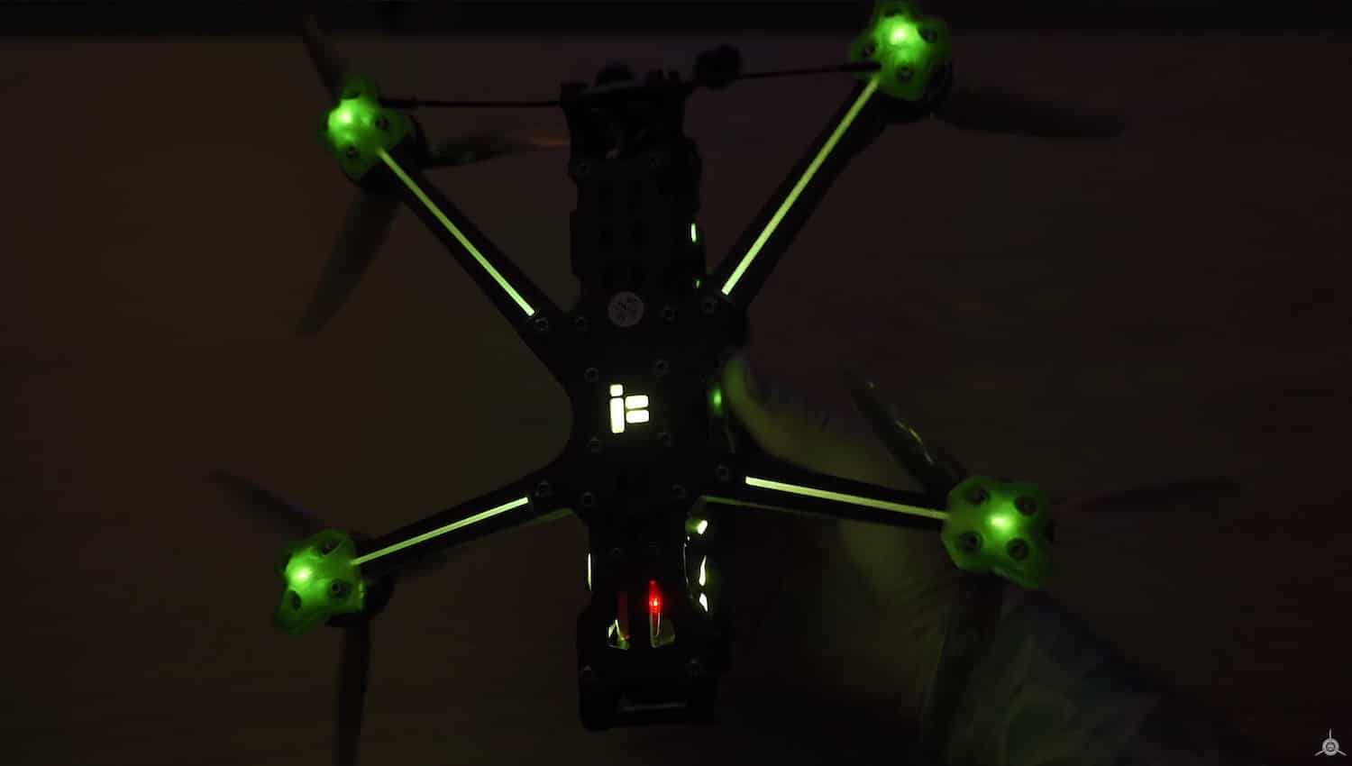 The iFlight FPV quadcopter glows with green propeller lights in the dark.