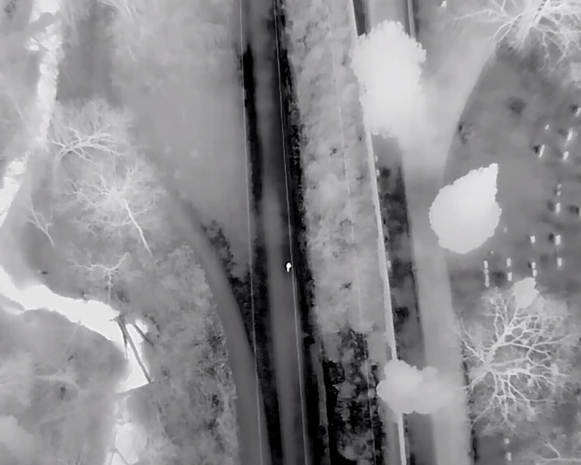 Thermal view from the M30T, where a person stands out against the cold ground.