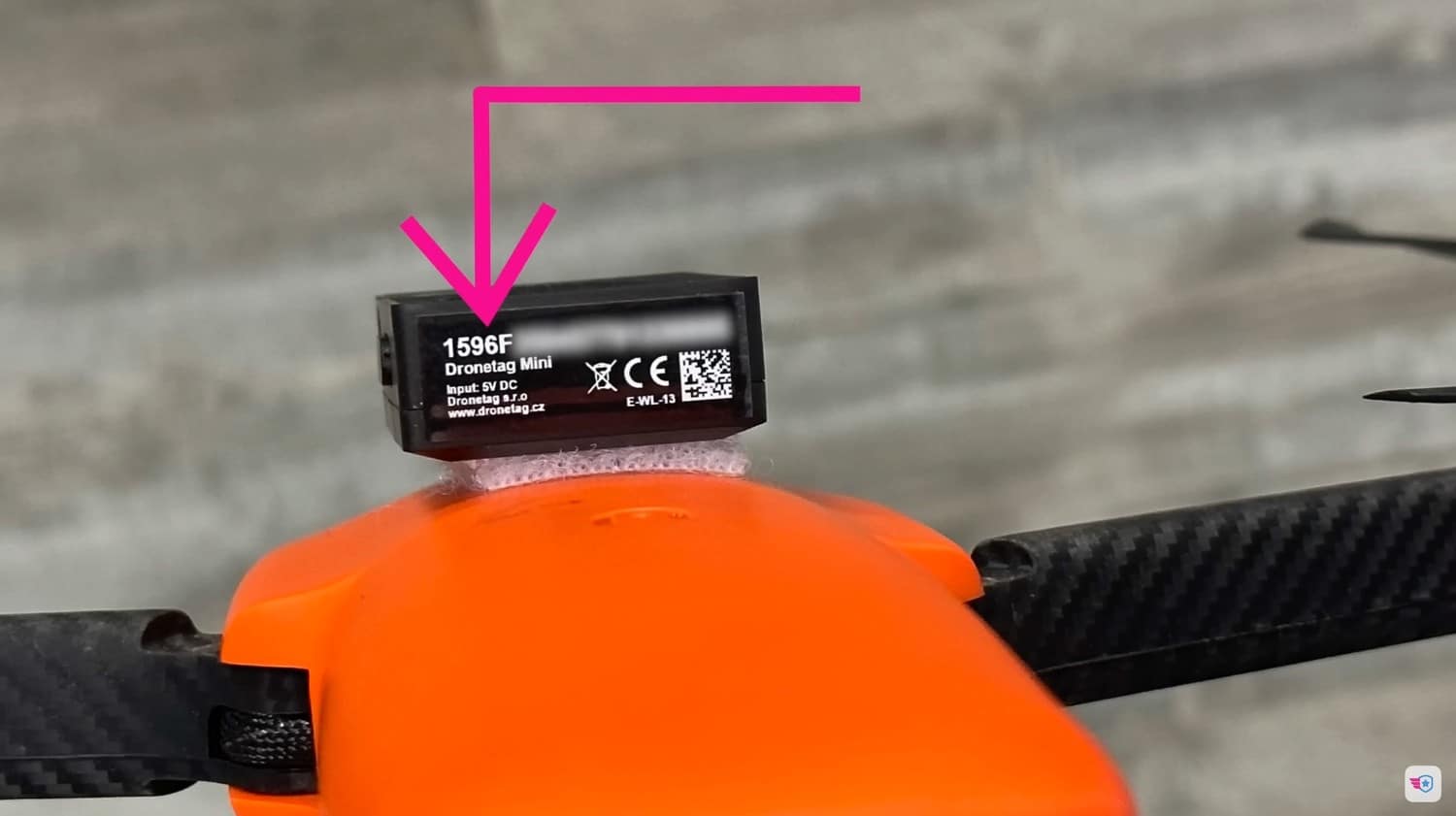 Dronetag Mini Remote ID module strapped with Velcro to the top of a drone.