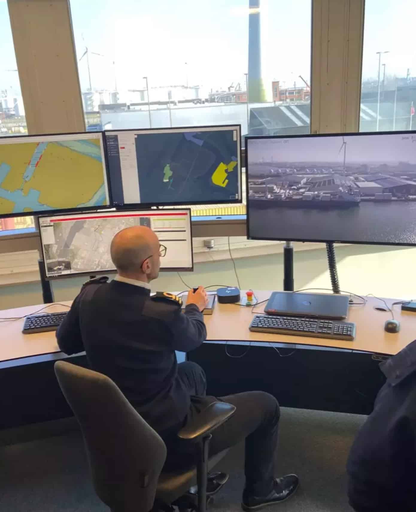 Operator monitors port drone flights from a control room lined with screens.