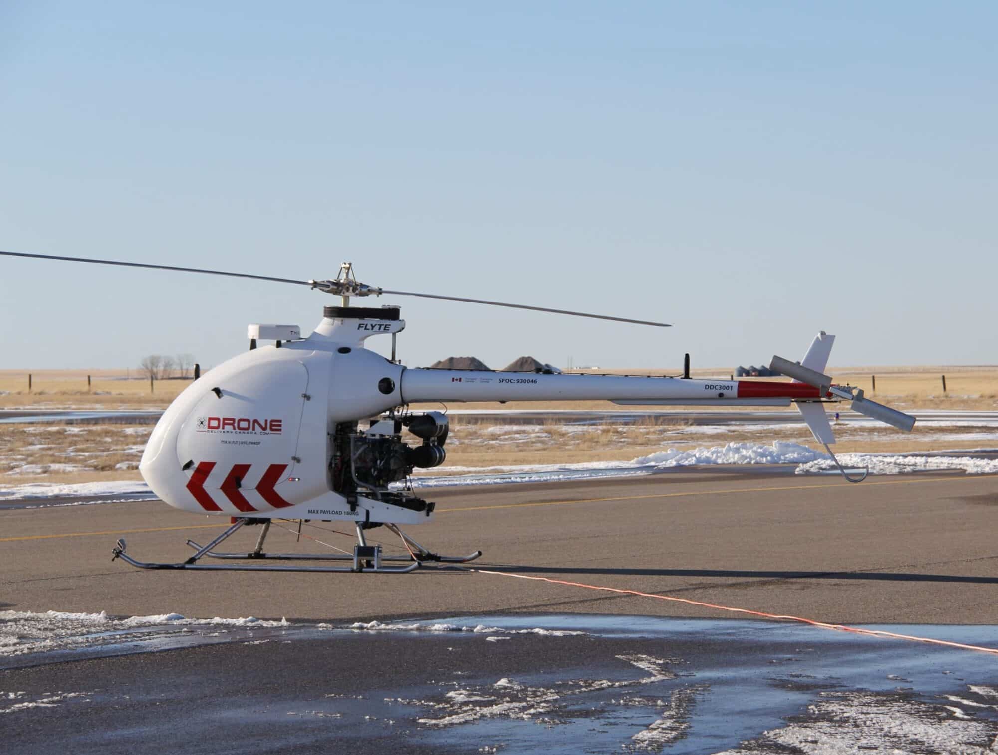 Drone Delivery Canada Condor unmanned helicopter parked on a snowy airfield.
