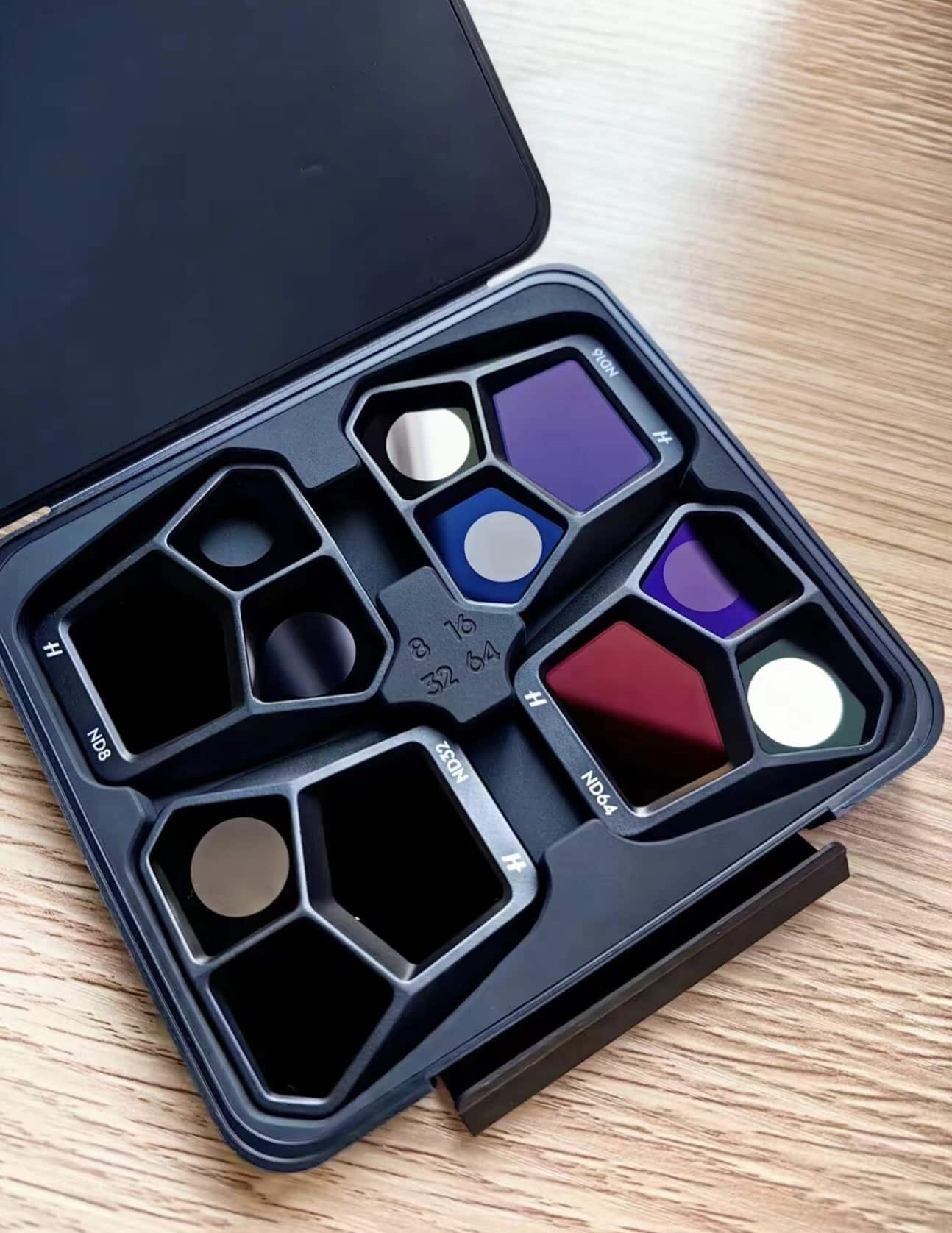 Open filter case holding hexagonal ND filters on a wooden table.