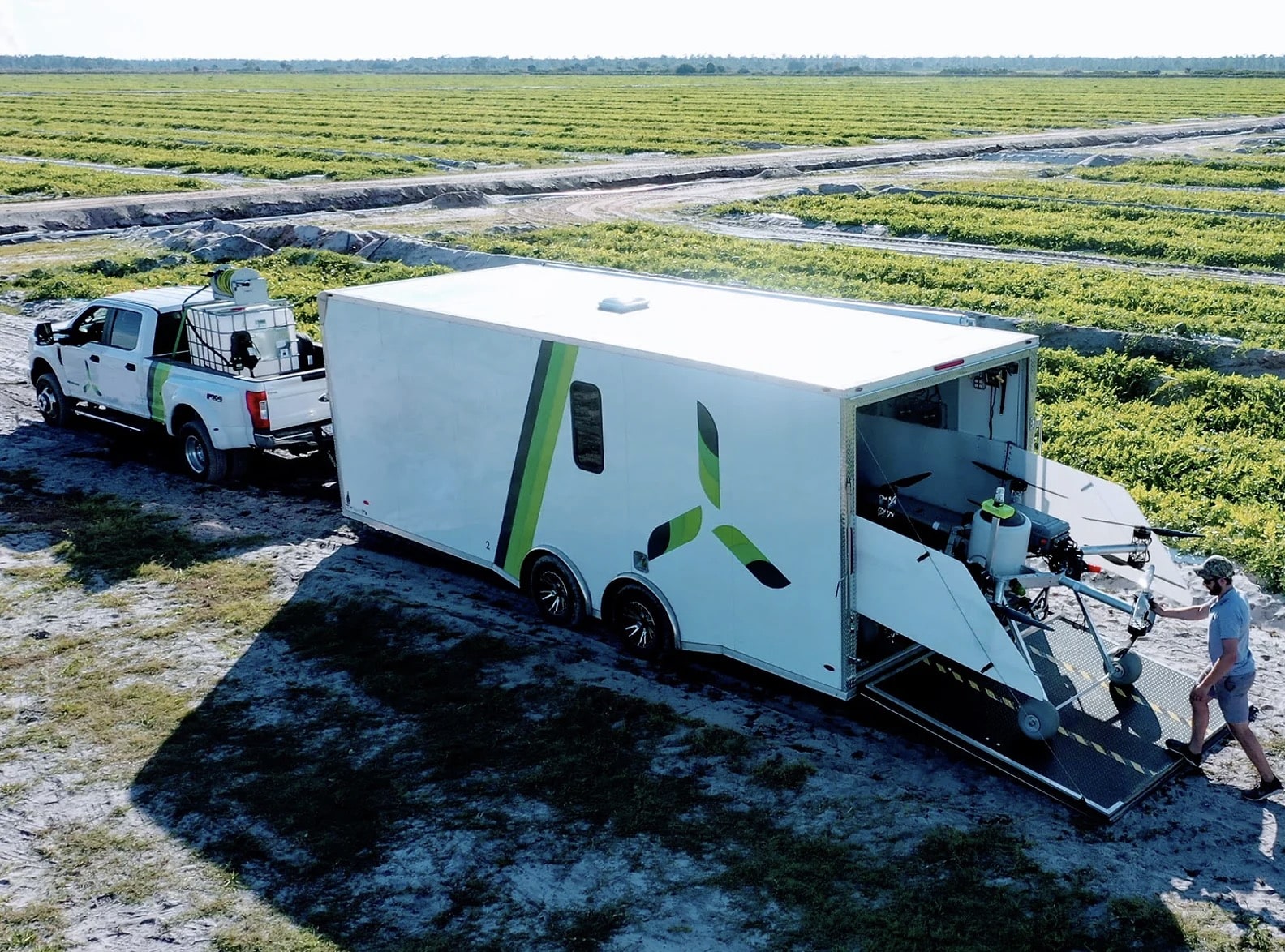 Guardian Agriculture support trailer and pickup staged at the edge of a field.