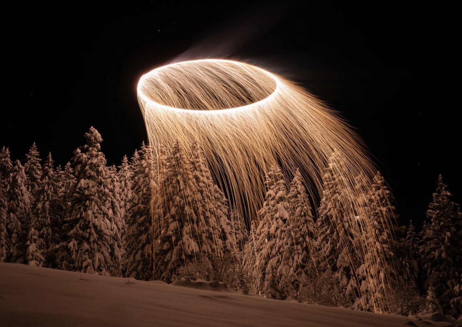 Ring of sparks traced by a drone carrying combustible powder over the French Alps.