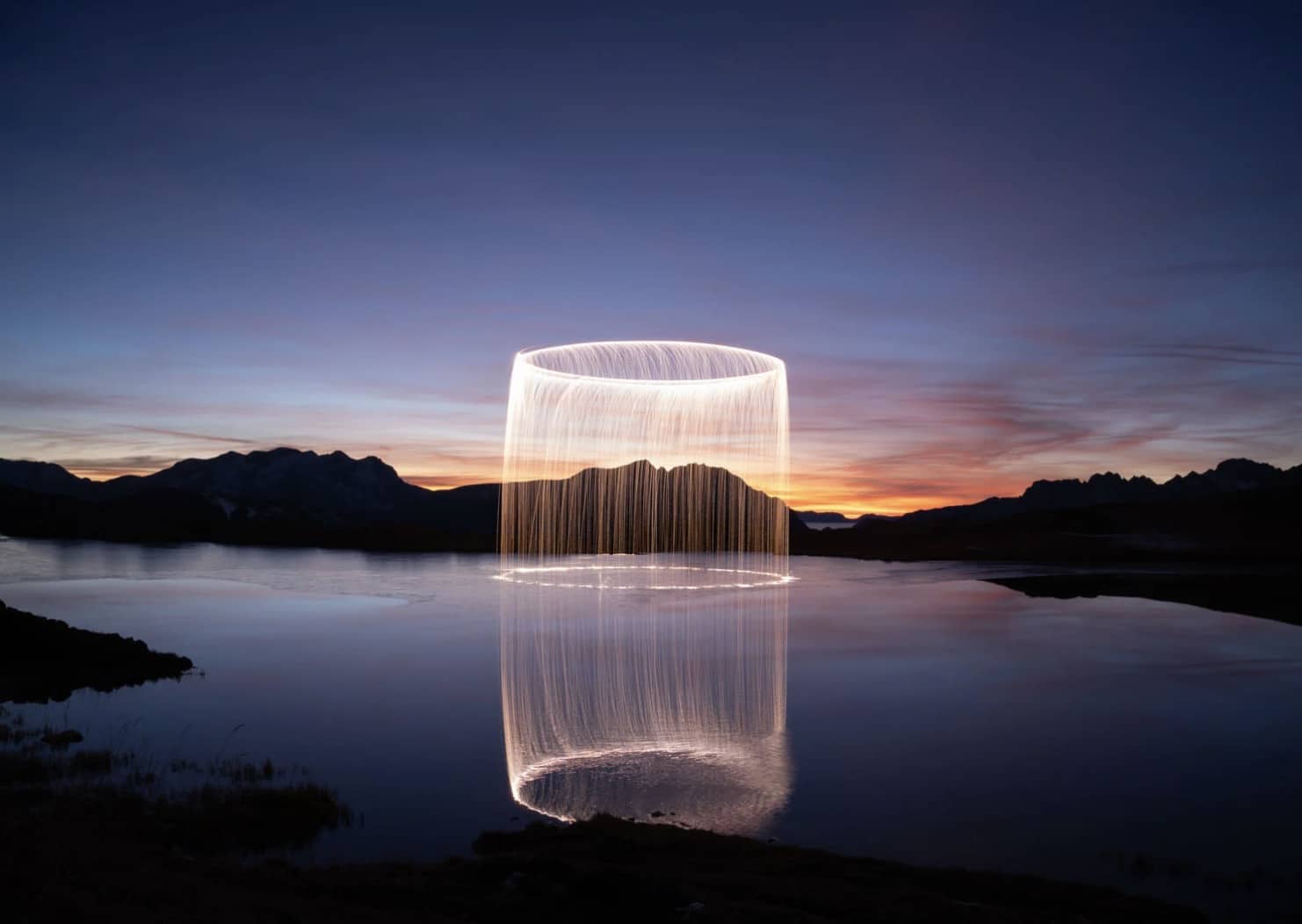 Fiery halo suspended over the mountains in Jadikan's drone light-painting series.