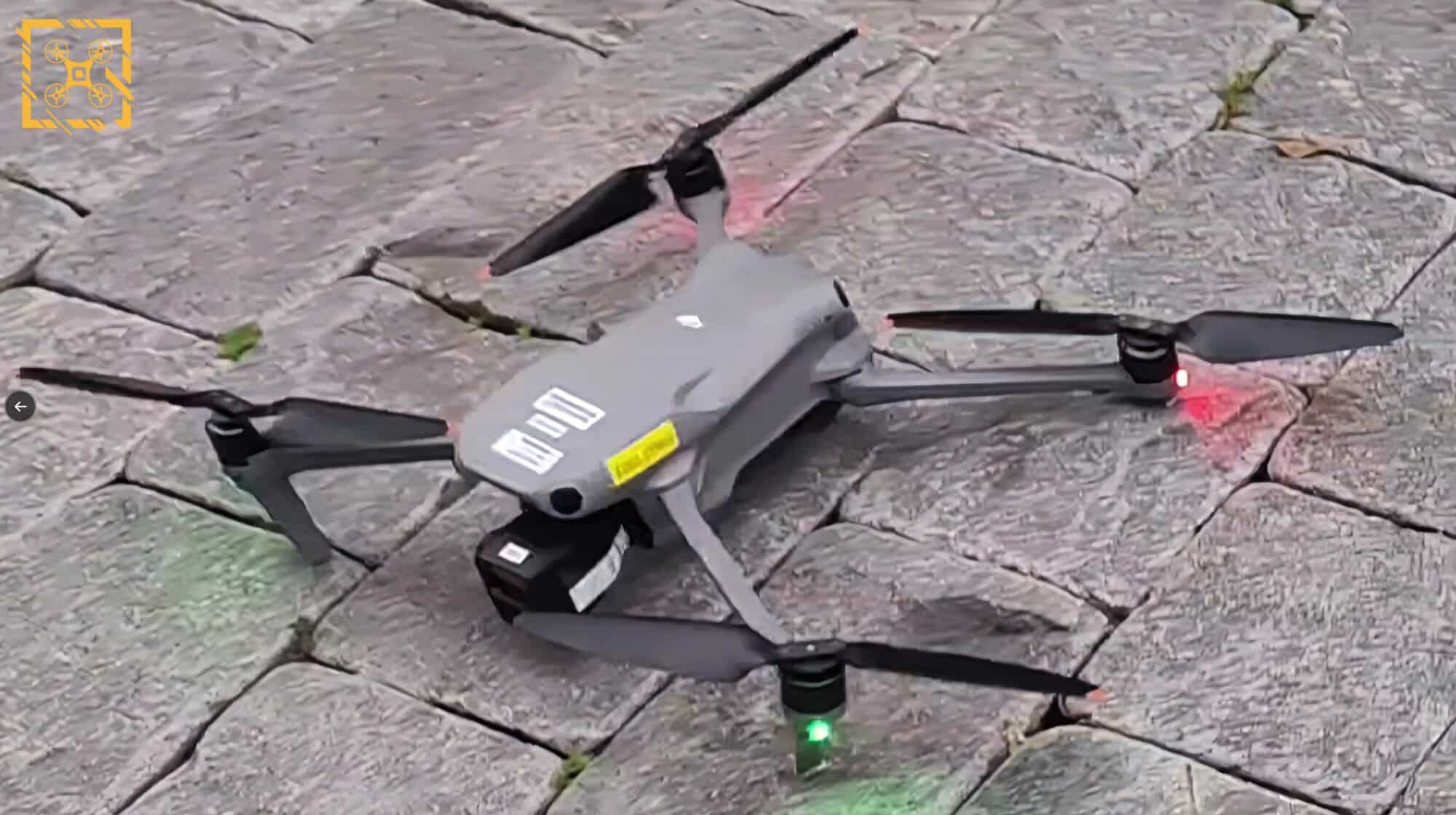 DJI Air 3 sits on worn cobblestones with its status lights glowing.