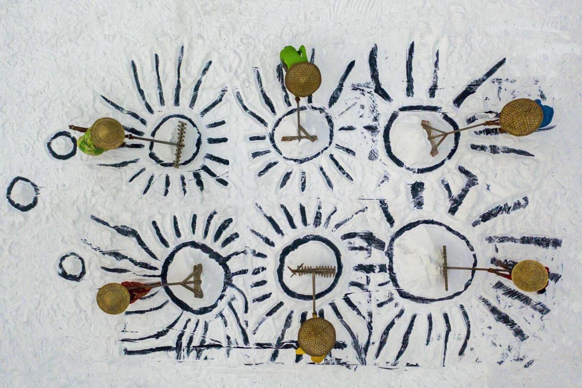 We Work Together by Pappu Chowdhury. On a mound of salt, two females and four males are engaged in forming designs.