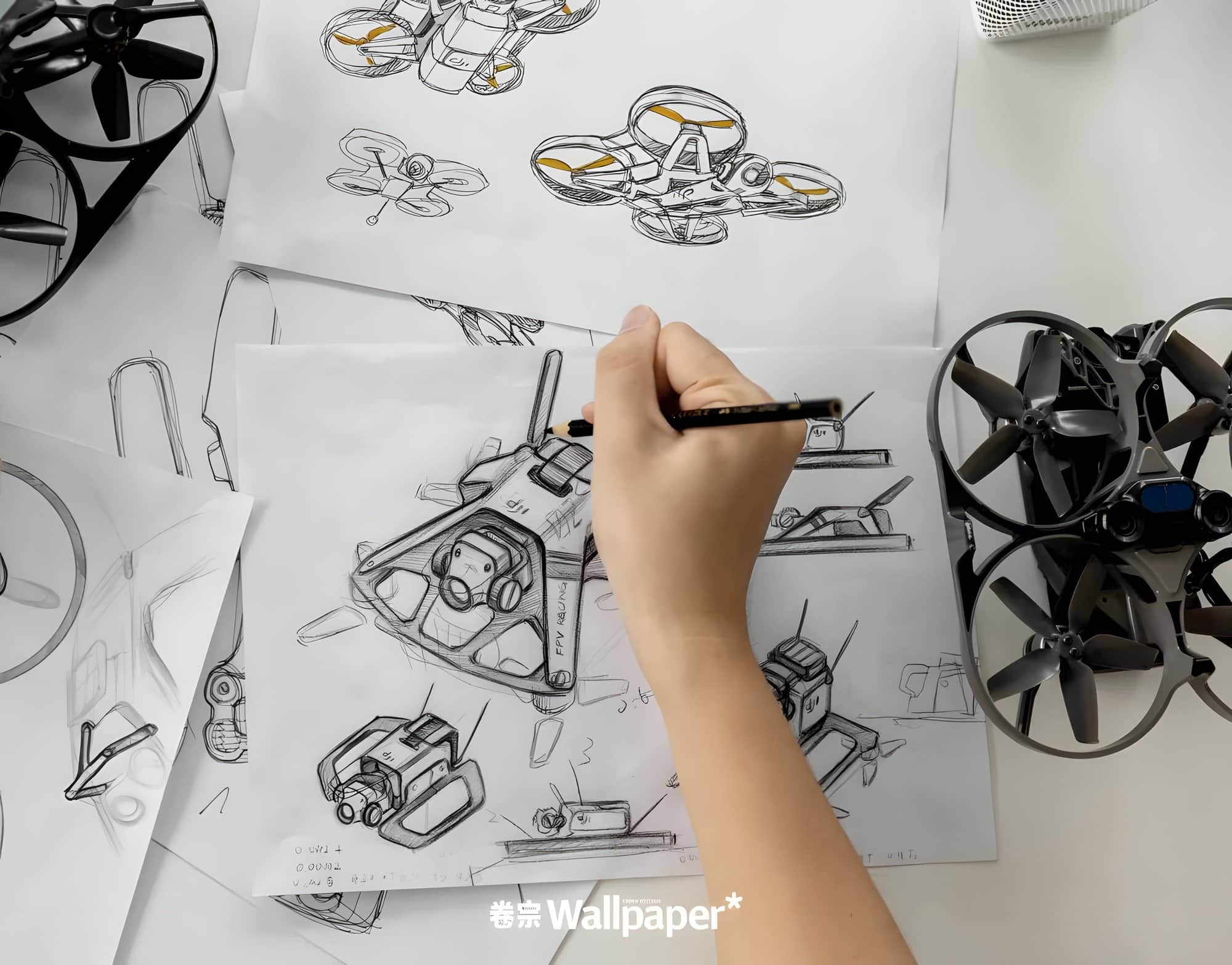 Hand sketching DJI Avata concepts on paper beside two ducted drone prototypes.