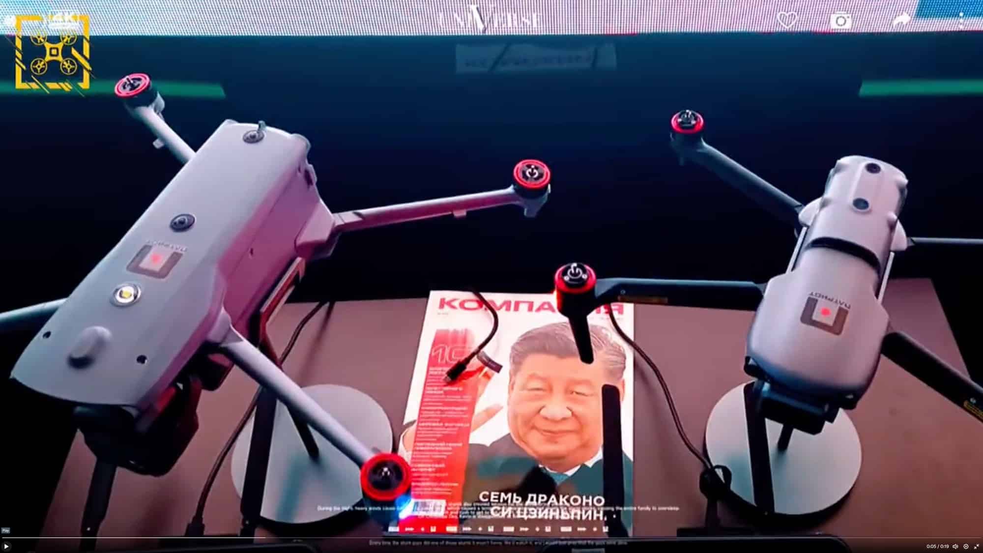 Two grey quadcopters displayed at a Russian forum flanking a magazine cover.