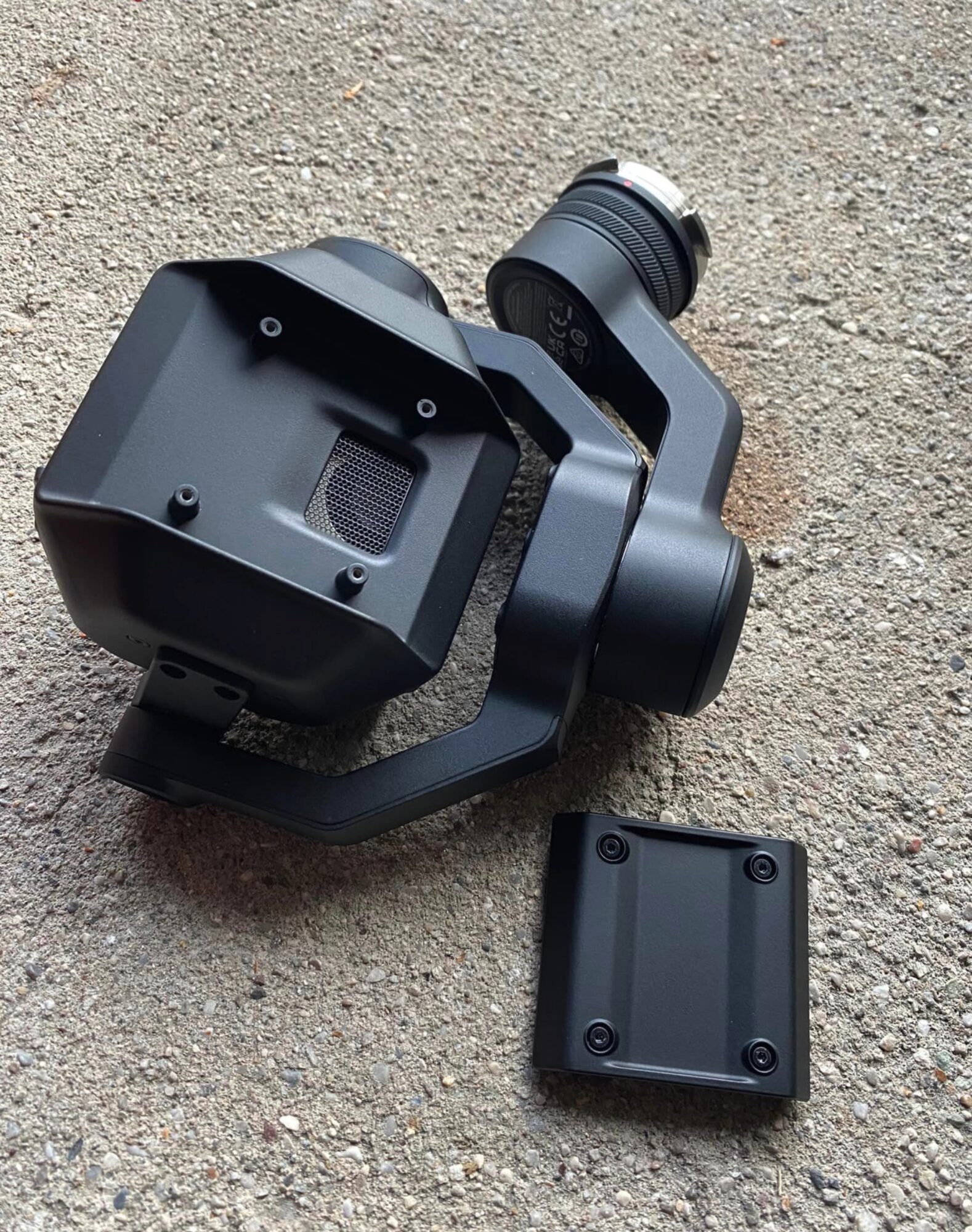 A DJI X9 Air camera body on gravel beside its detached DL mount.