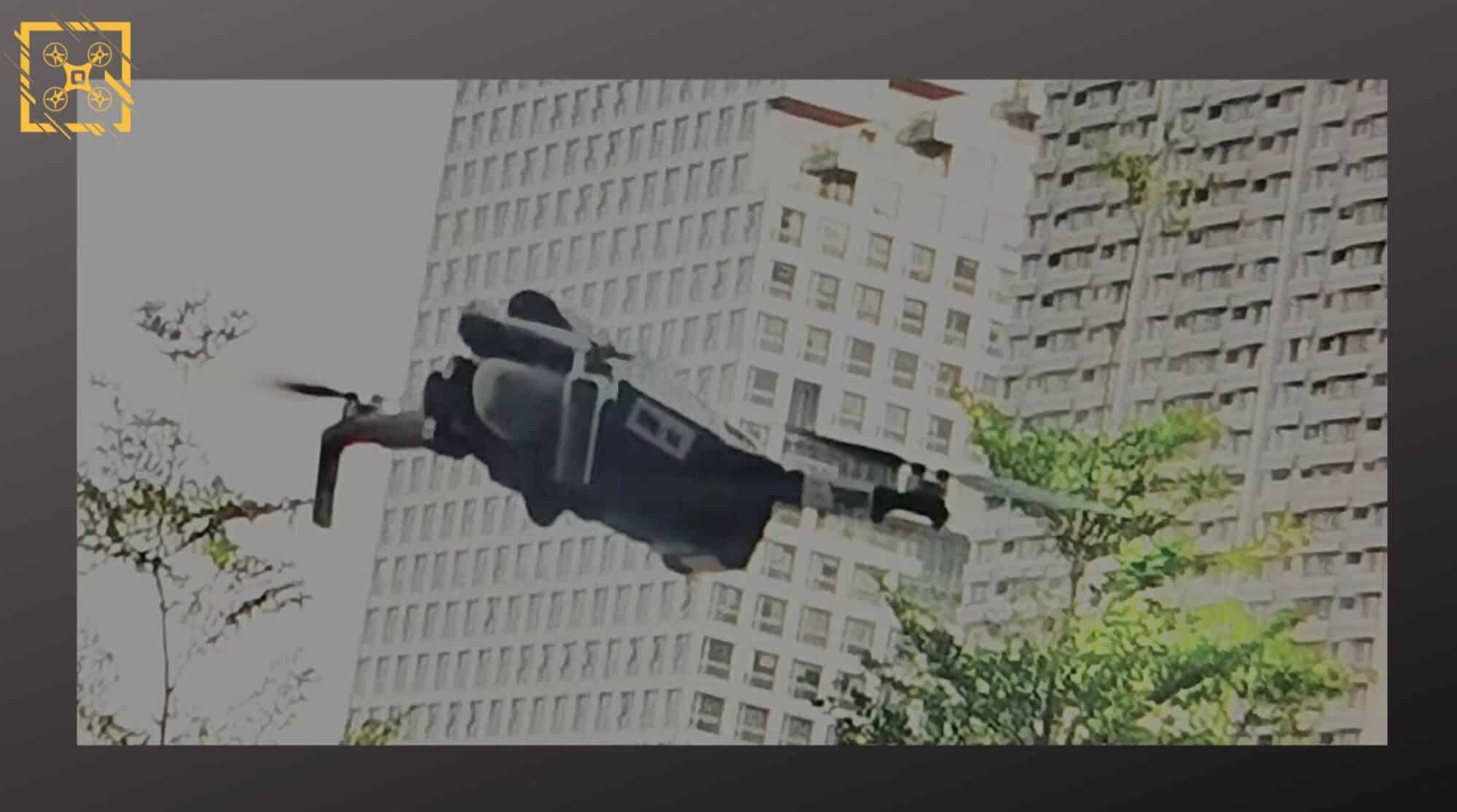 Grainy tracking screenshot of a drone in flight in front of a tall apartment block.