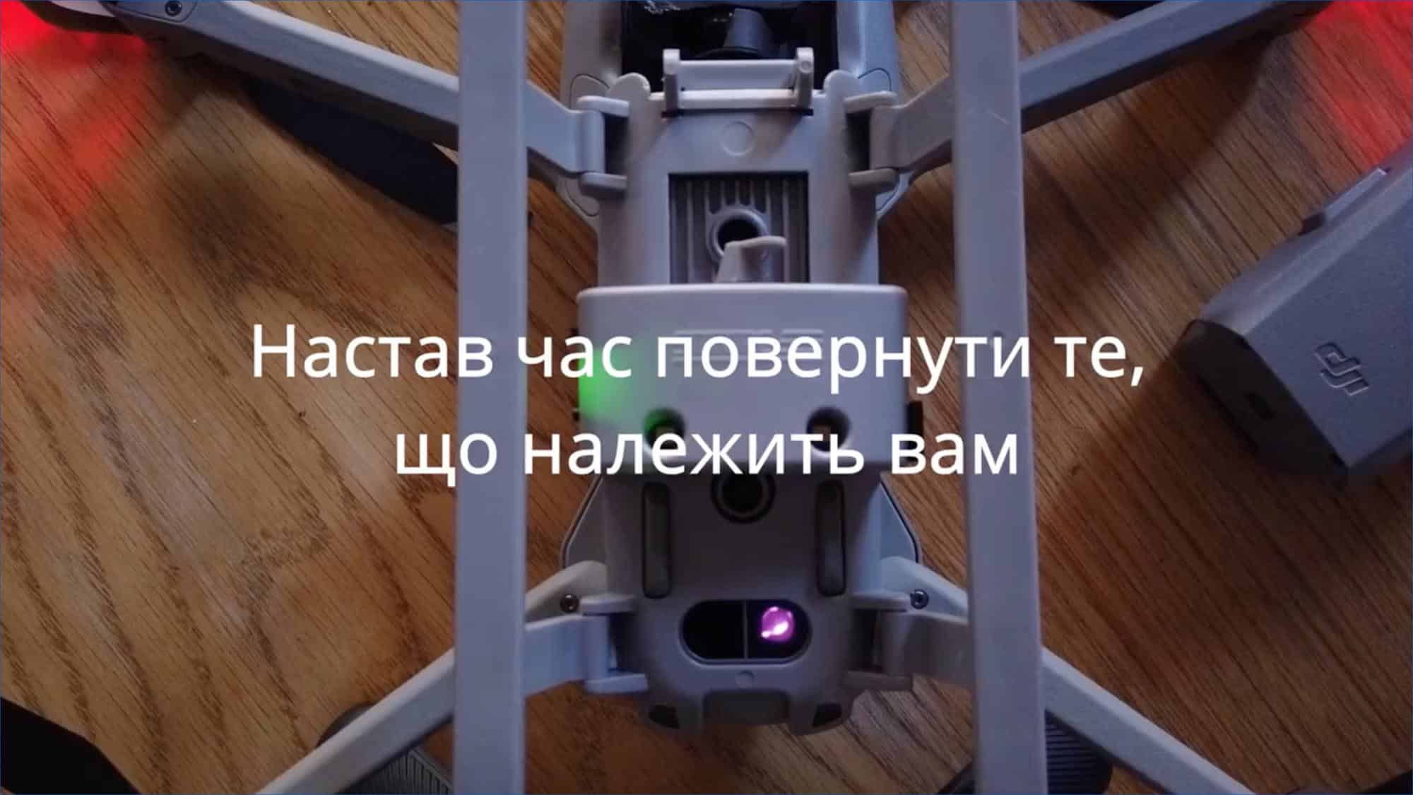 Close-up of a folding drone on a table with Ukrainian subtitles overlaid.