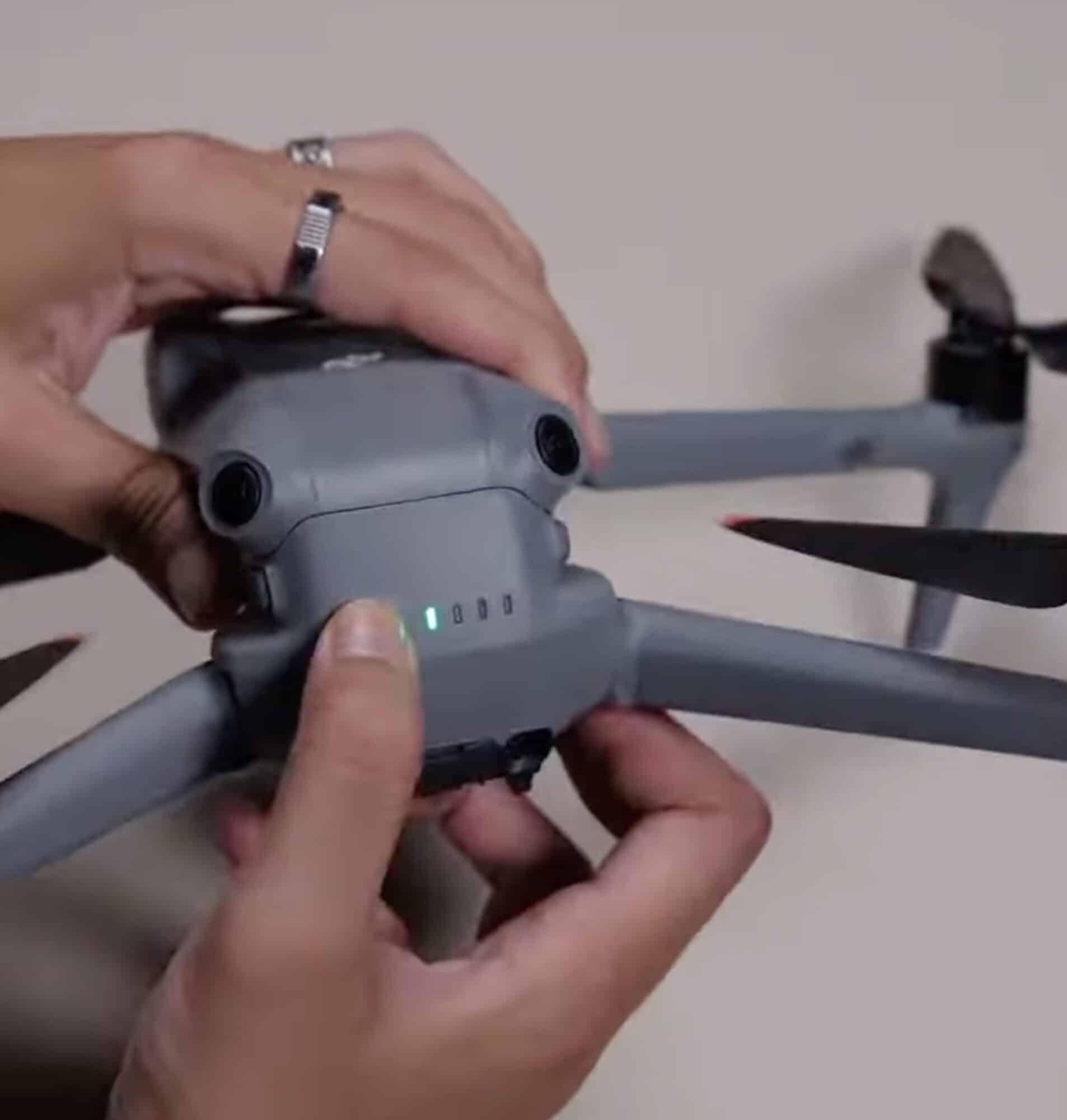 Hands slide the intelligent flight battery into the top of the Air 3.
