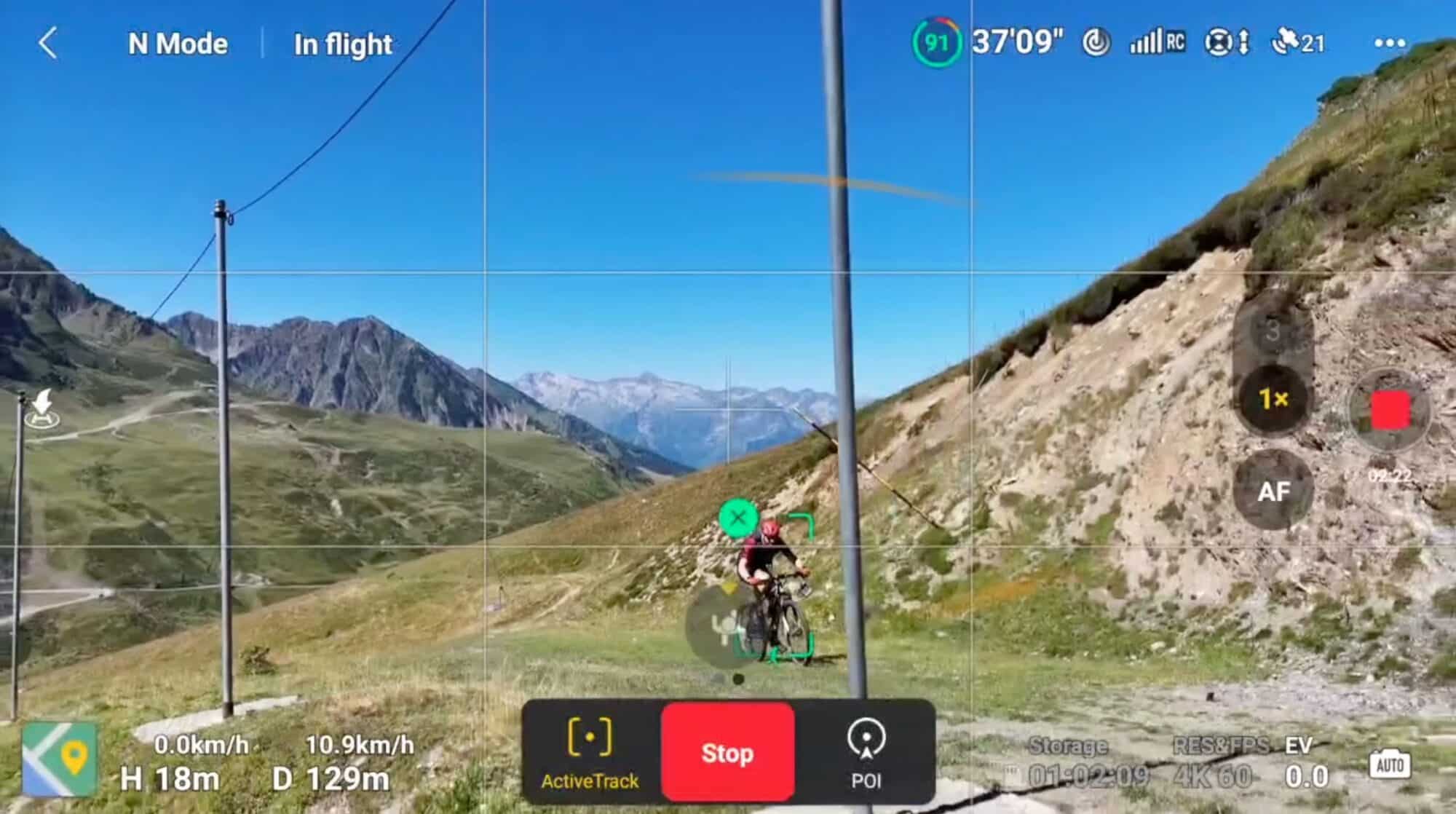 The Air 3 threading between poles and ski nets above a mountain biker.