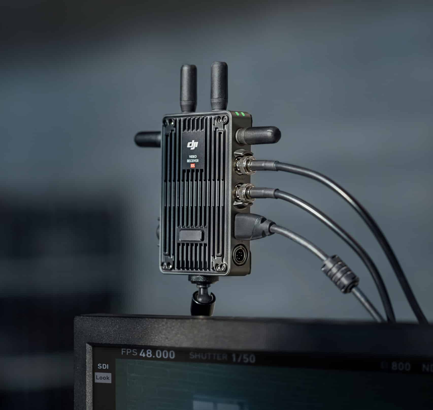 DJI Transmission video transmitter with antennas clamped above a production monitor.