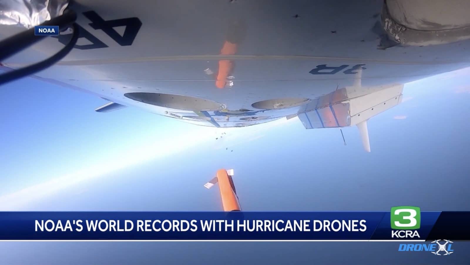 NOAA news segment showing a small drone mounted under an aircraft wing.