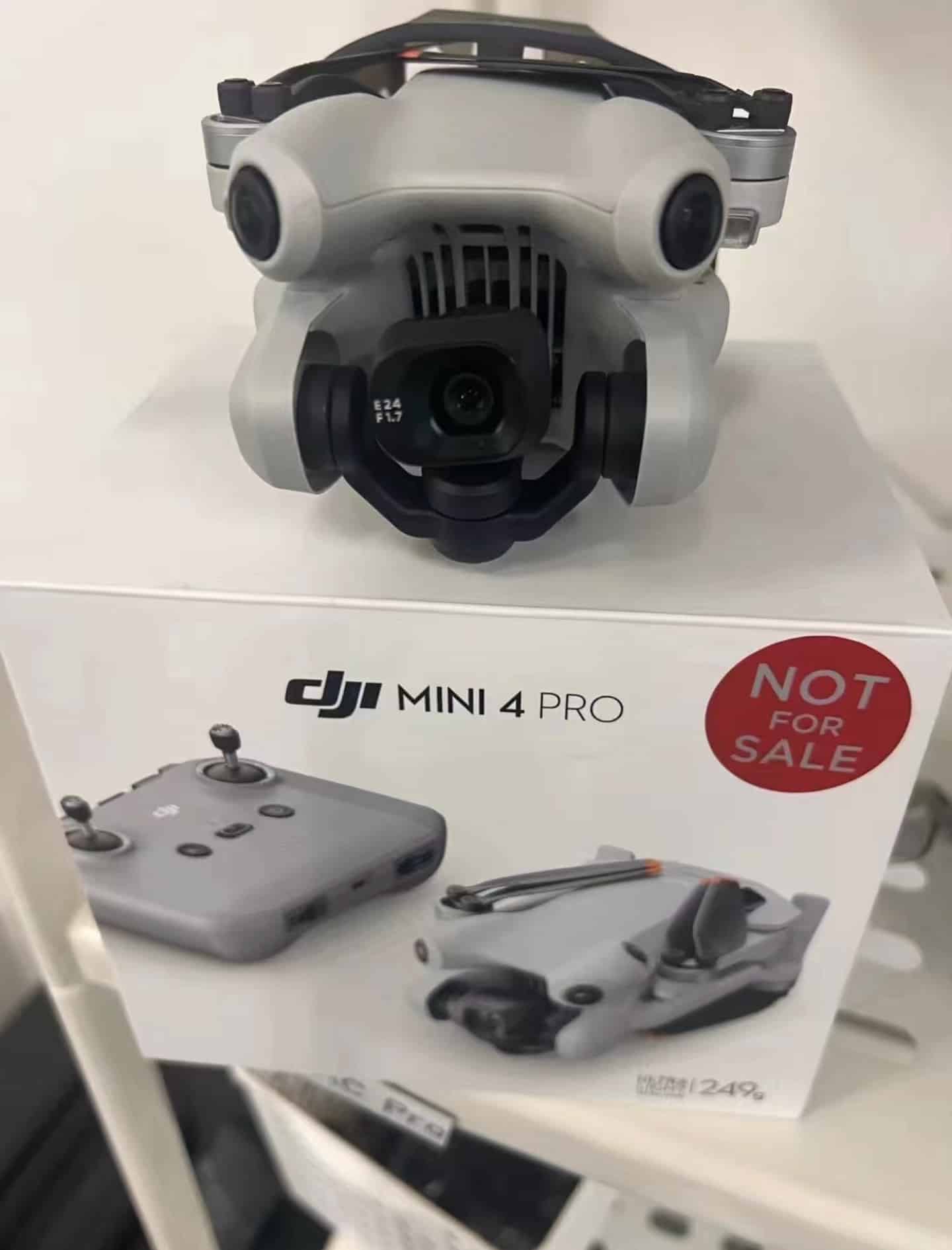 DJI Mini 4 Pro standing on its retail box with a red not-for-sale sticker.