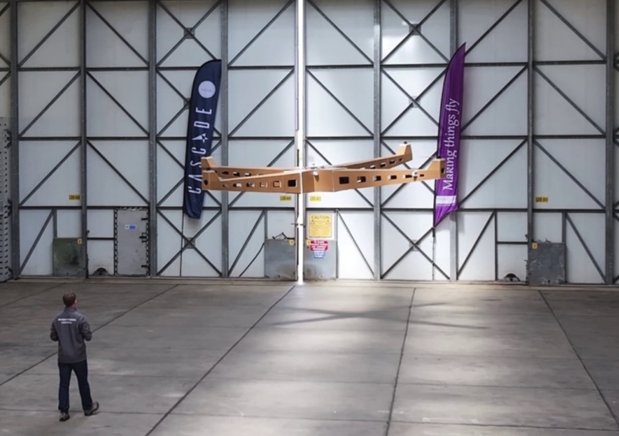 Giant foamboard quadcopter dwarfing a person inside a University of Manchester hangar.