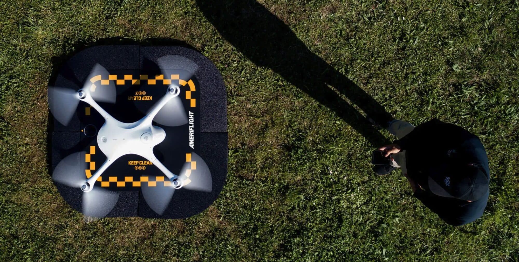 Overhead view of a Matternet M2 on its landing pad on grass.