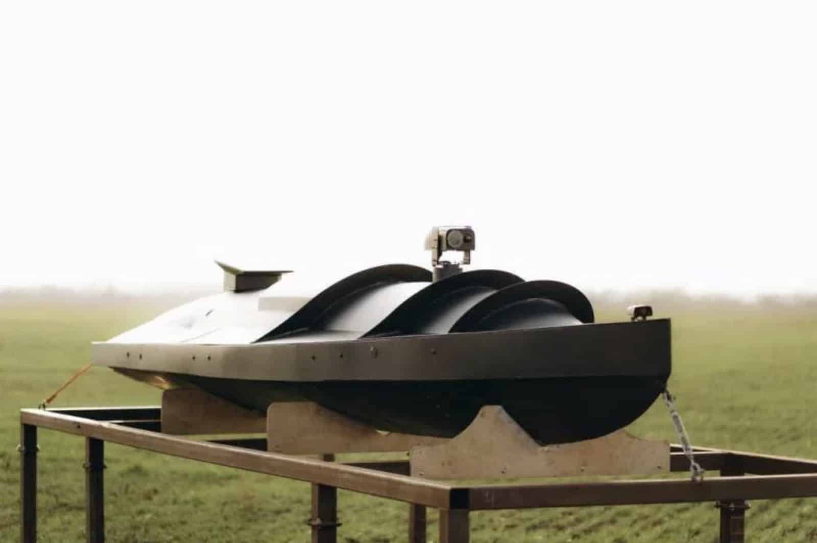 Ukrainian naval attack drone resting on a stand in an open field.
