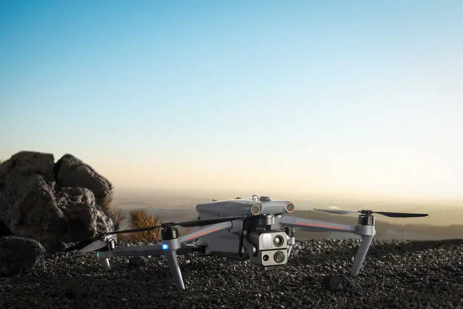 Autel drone sits on gravel at sunset with its sensor pod facing forward.