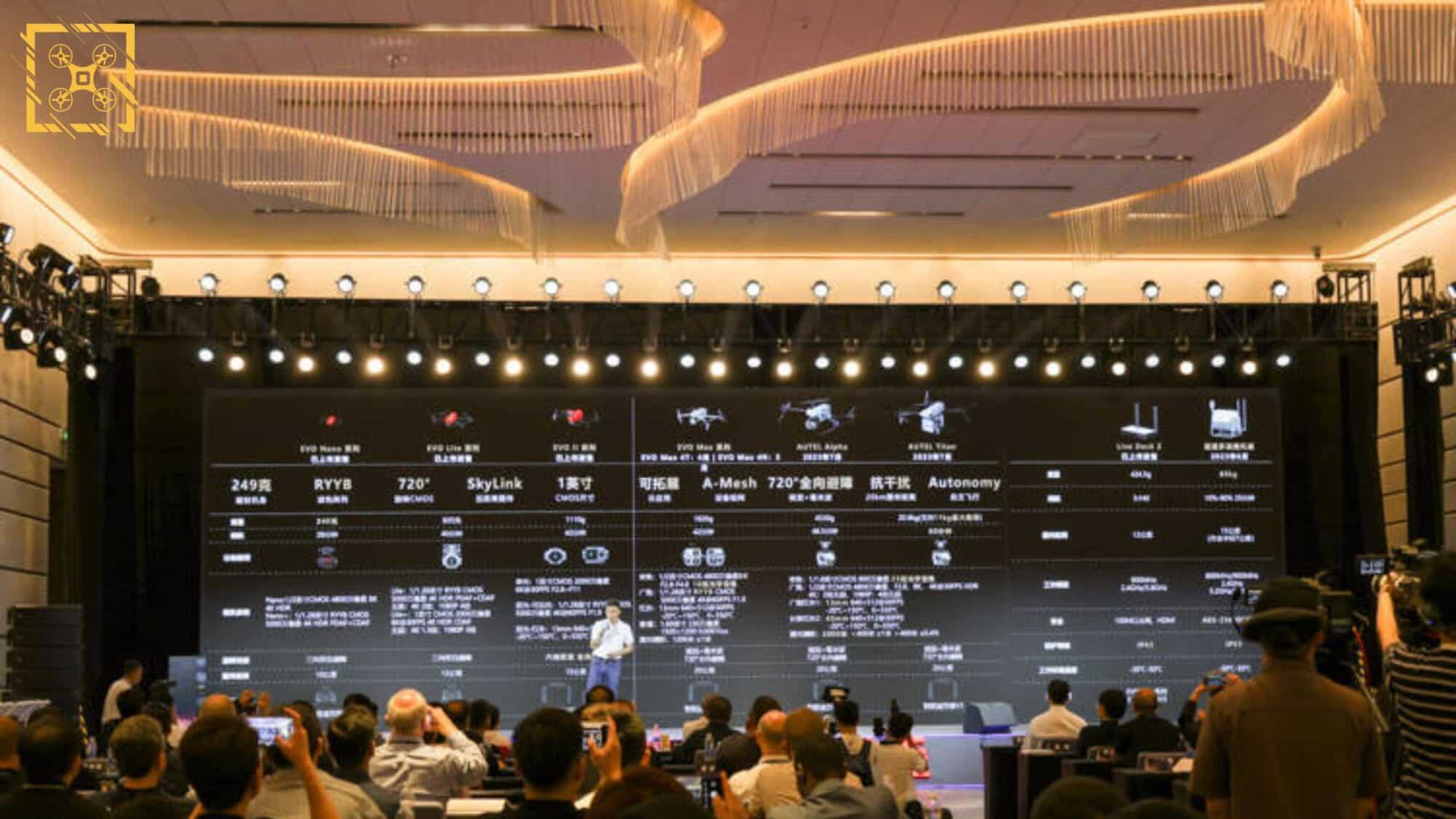 Audience faces a lit stage and product wall during an Autel Robotics conference.