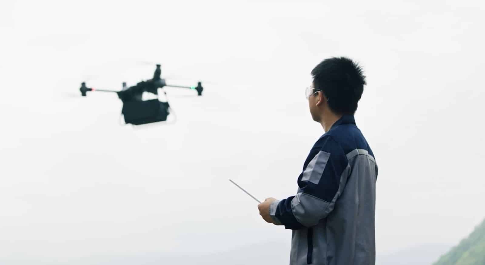 An operator watches the FlyCart 30 fly while holding the remote controller.