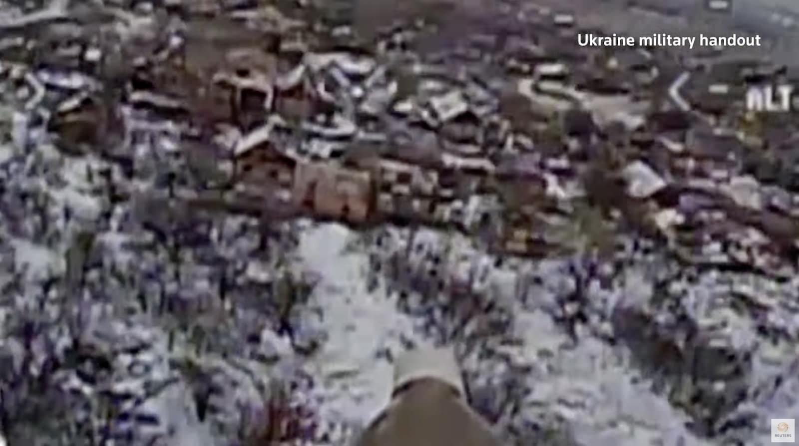Grainy drone footage of a destroyed vehicle in a snowy field, marked a military handout.