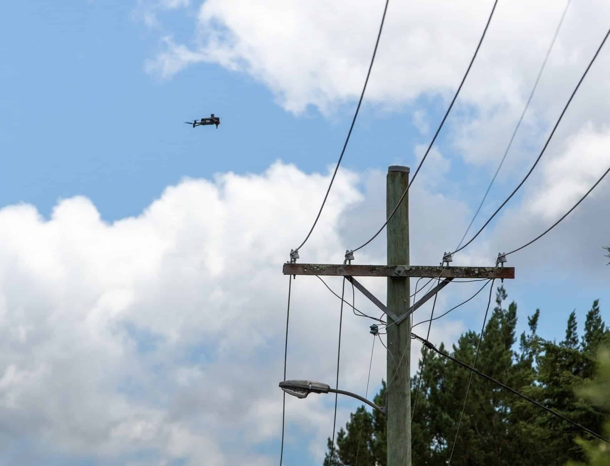 Enterprise drone capturing detailed imagery of electrical infrastructure along a pre-programmed route.