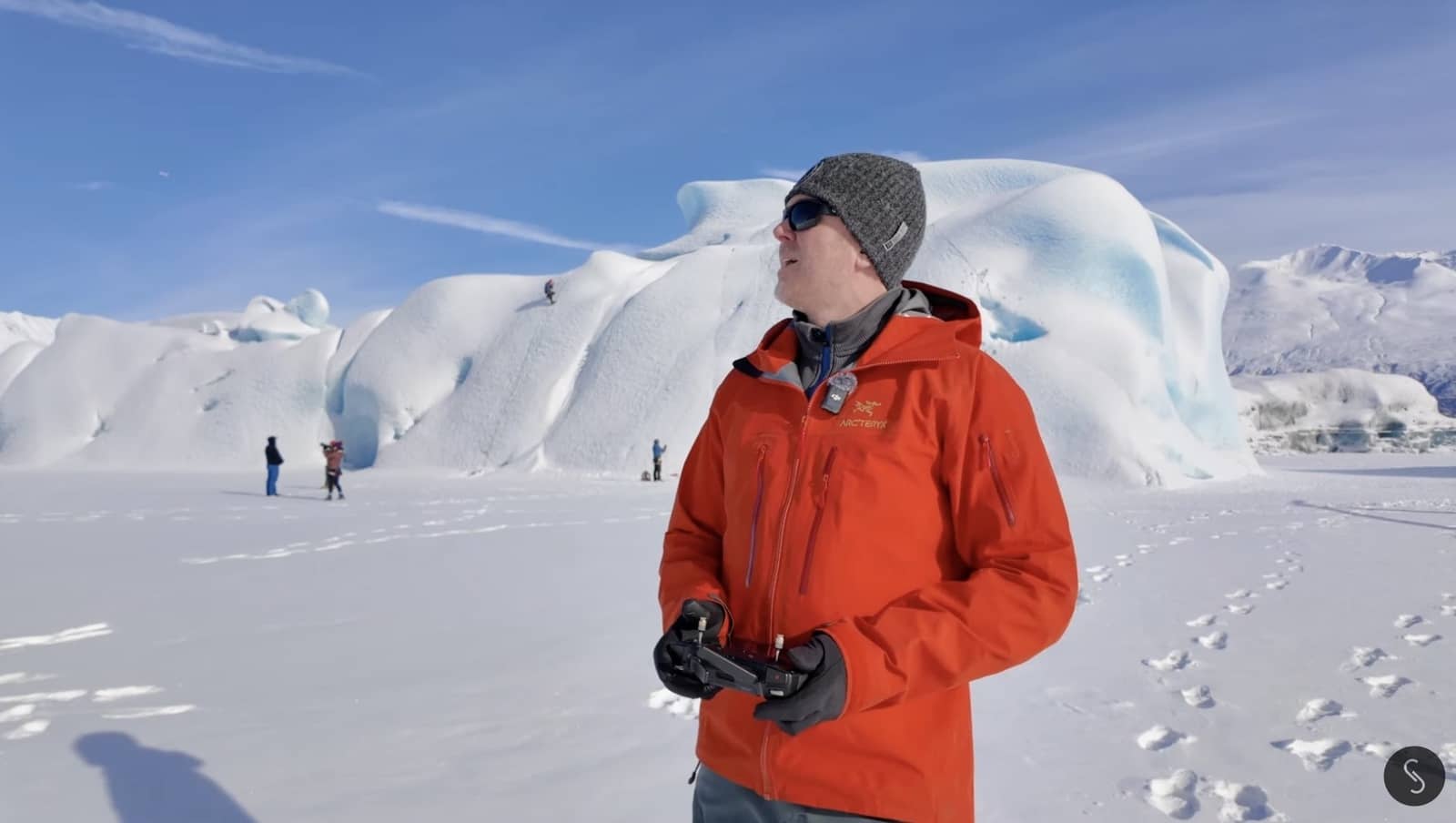 Wide drone shot of the iceberg and frozen lake where the climbers are working.