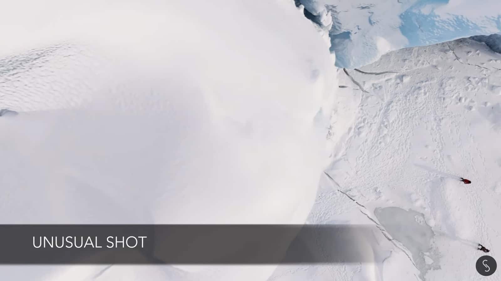 Pullback drone shot as the climber summits the top of the iceberg.