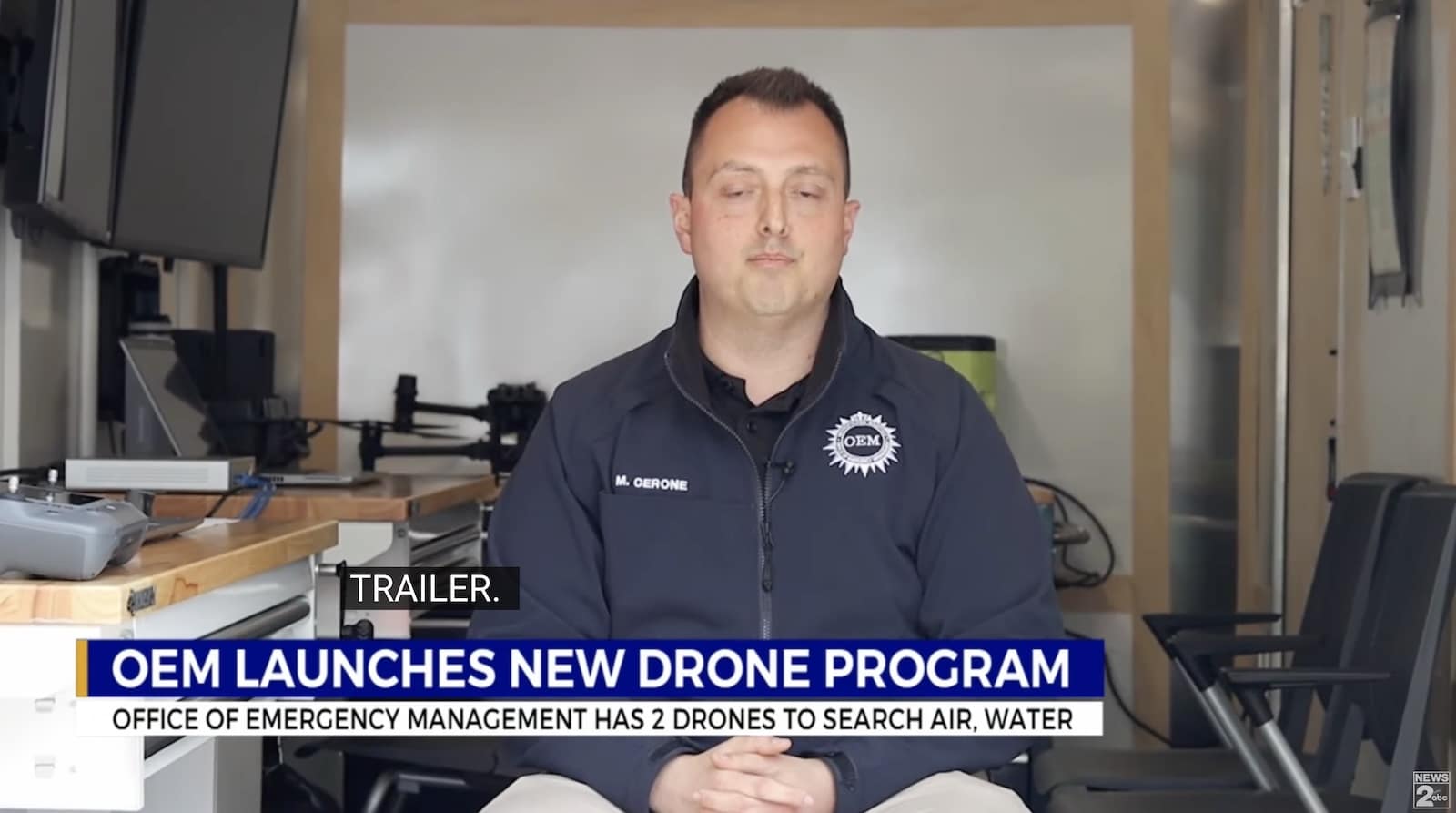 News interview with an emergency management official as a drone program chyron runs.
