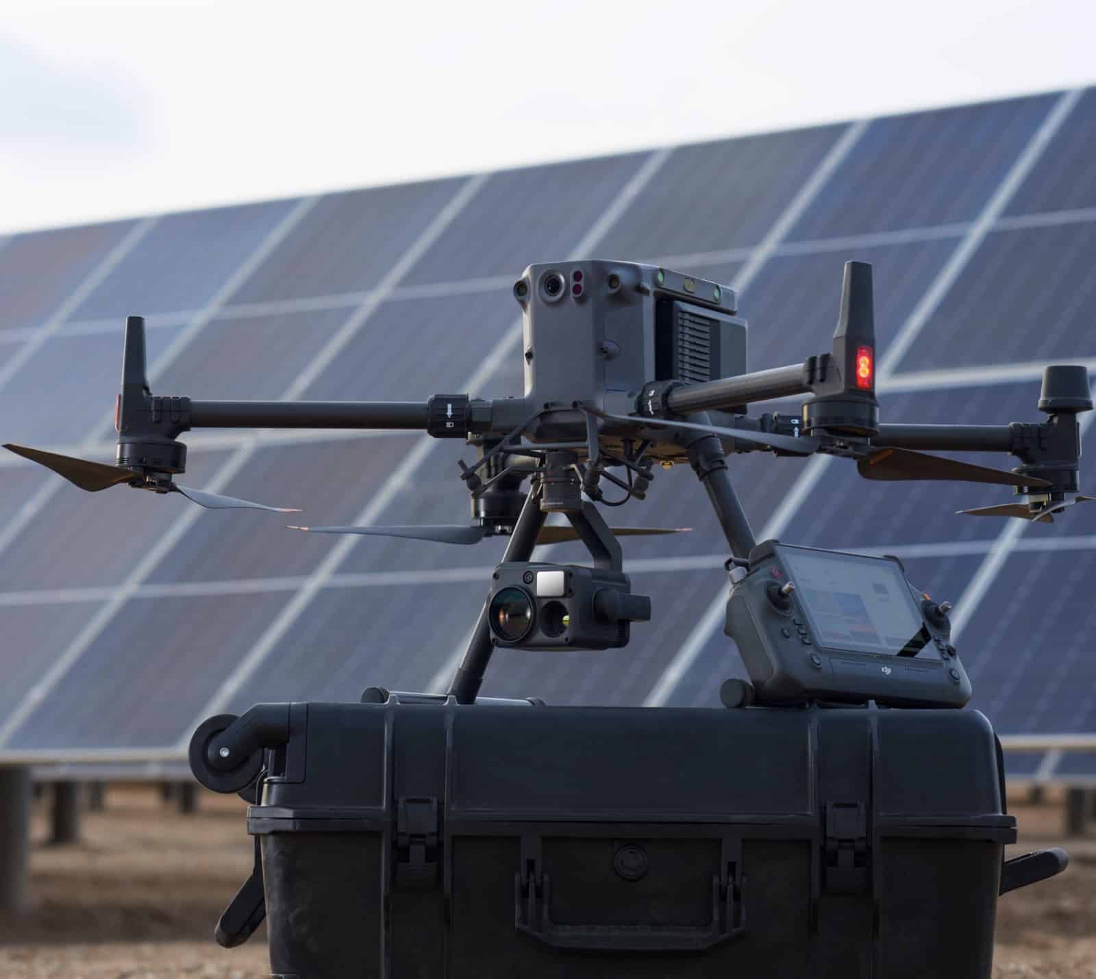 DJI Matrice drone on a hard case in front of a solar panel array.