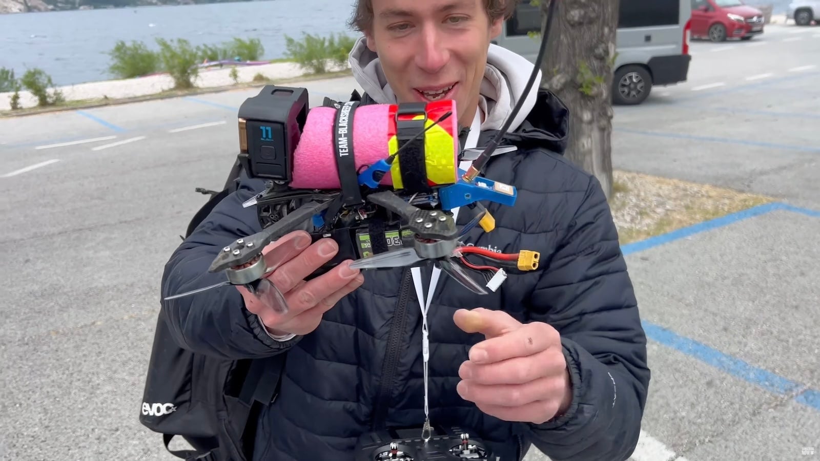 Low FPV drone pass over a windsurfer riding a hydrofoil at speed.