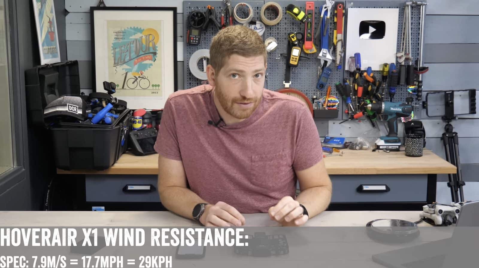 Reviewer at a workbench under an overlay rating wind resistance at 17.7 mph (29 km/h).