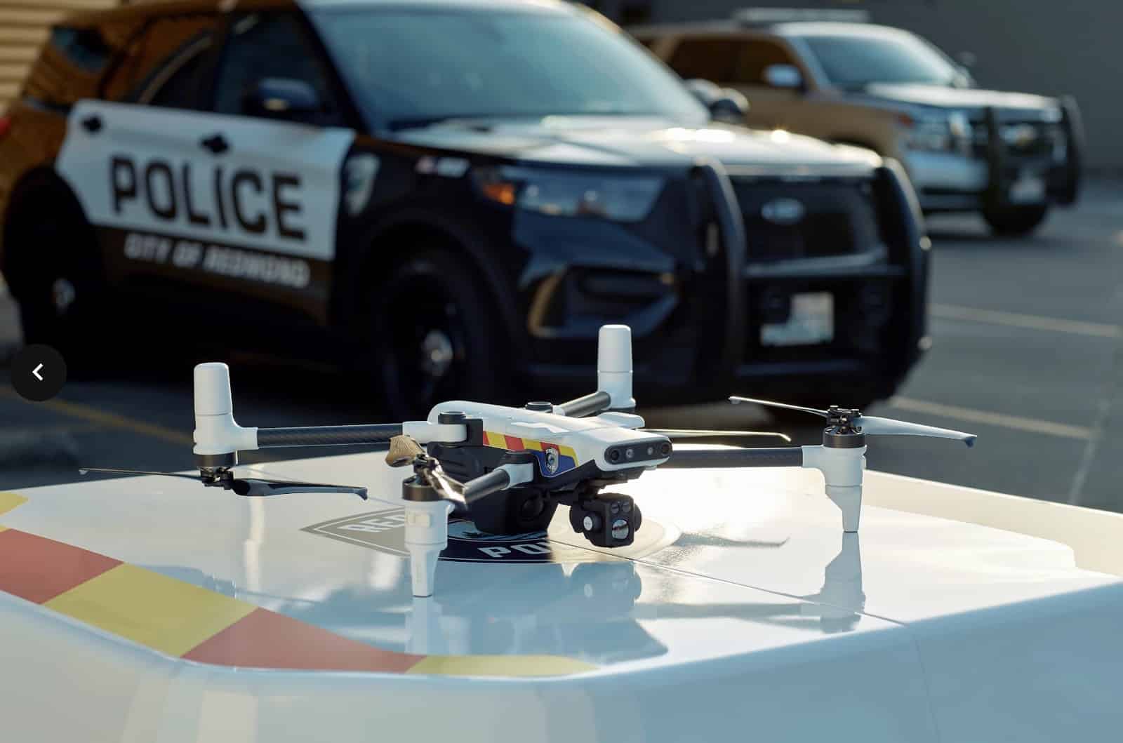 The BRINC Responder sits on its launch pad in front of patrol vehicles.