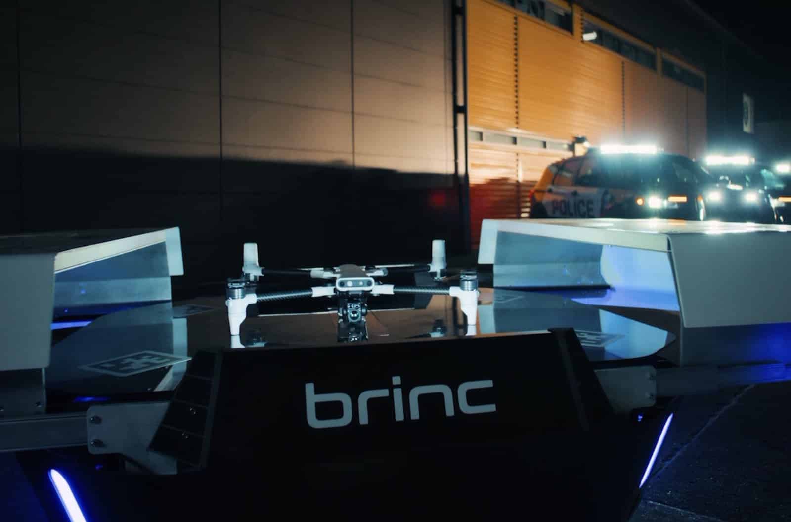 A BRINC drone sits in its open, illuminated launch station at night.