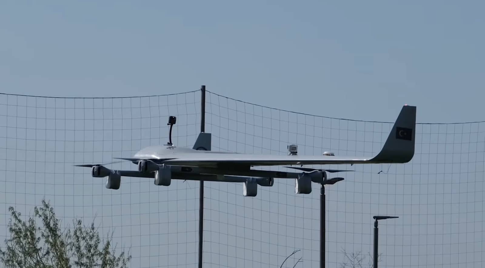 Side view of the aircraft hovering behind a safety net, Turkish flag on the winglet.
