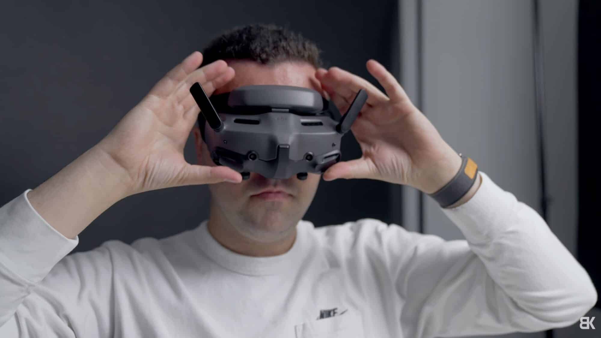 Man pulling the DJI Goggles 3 down over his eyes in a studio.